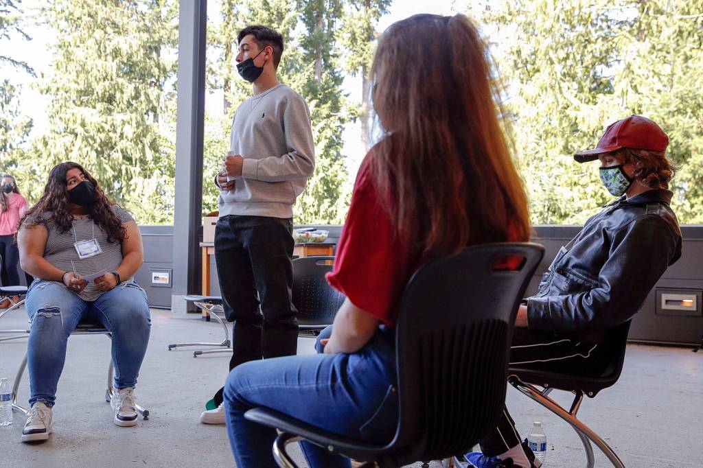 Hugo Barbosa Cedano Jr. (standing) gives a speech with Christine Helo (left), Adrian Bostrom (right) and Emily Heck (front) during a public speaking clinic for the newly formed Marysville Youth Advocacy Committee. (Kevin Clark / The Herald)