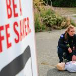 Capt. Kate Songhurst demonstrates proper CPR during the launch press briefing for the PulsePoint app Tuesday at Kasch Park in Everett. (Kevin Clark / The Herald)