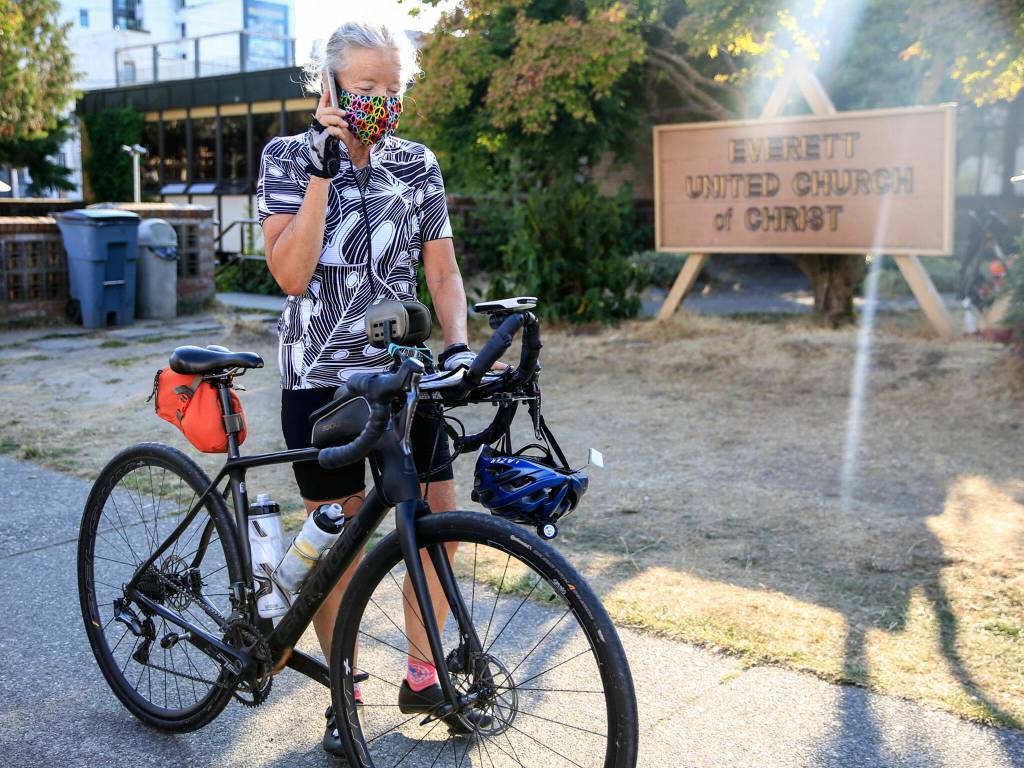 Lynn Salvo takes a call after arriving at the Everett United Church of Christ Tuesday. (Kevin Clark / The Herald)