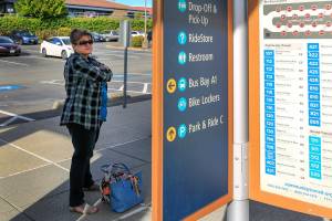 Heather Van Slageren waits for a Community Transit bus to Stanwood at the Lynnwood Transit Center on September 8, 2021. (Kevin Clark / The Herald)