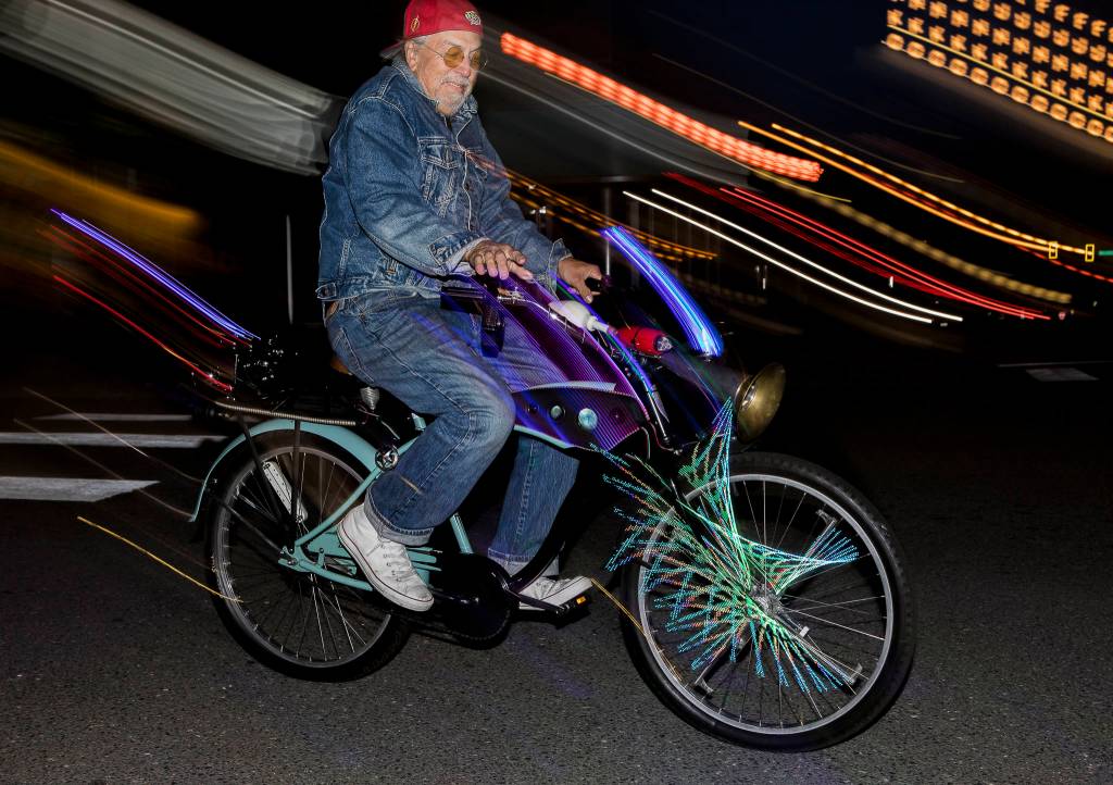 Reggie Miles rides his illuminated bike down Colby Avenue on Saturday in Everett. (Olivia Vanni / The Herald)