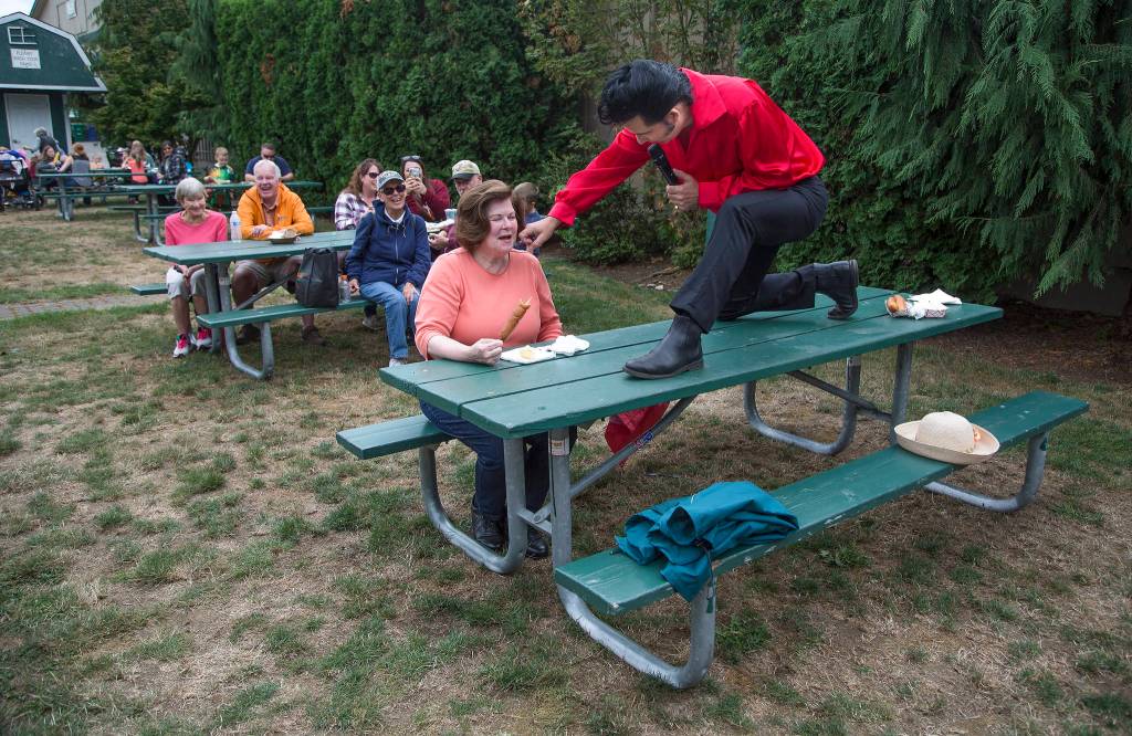 Danny Vernon, Illusion of Elvis Presley tribute impersonator, jokes that Dee Rigelman has mustard on her cheek as he performs at the Evergreen State Fair on Monday in Monroe. (Andy Bronson / The Herald)