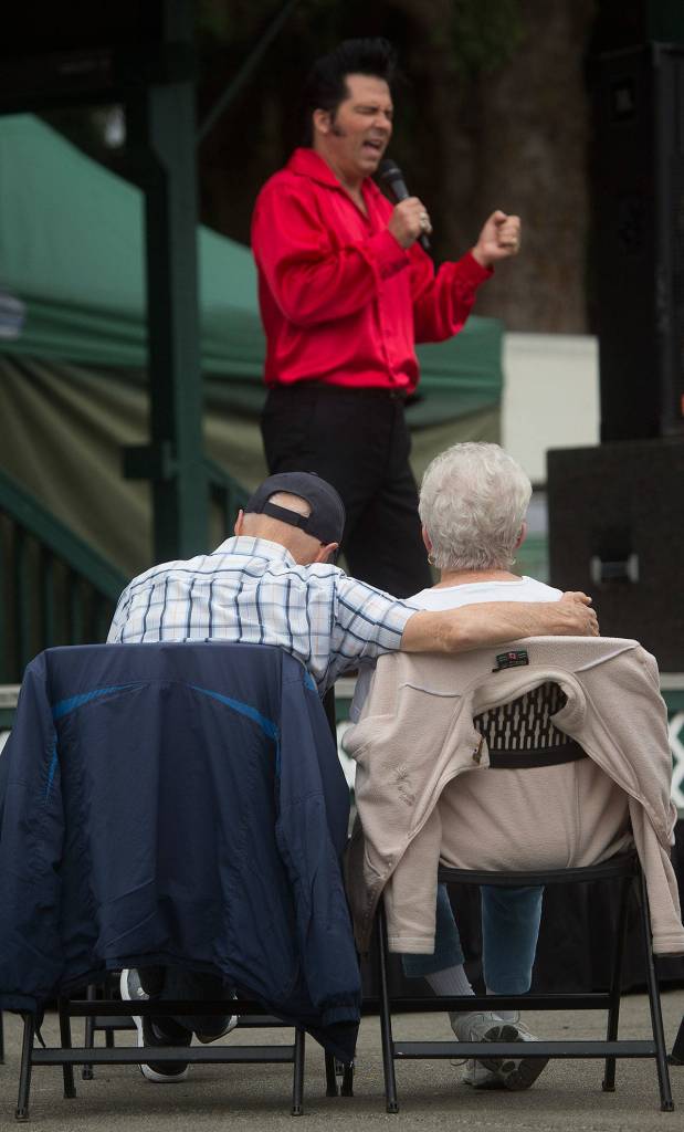 A couple watches Danny Vernon, Illusion of Elvis Presley tribute impersonator, perform at the Evergreen State Fair on Monday in Monroe. (Andy Bronson / The Herald)