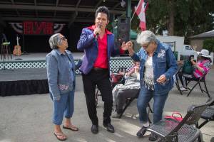 Danny Vernon, Illusion of Elvis Presley tribute impersonator, twirls Celia Salinas as her sister Rosa Cantu, left, waits to dance with Vernon as he performs at the Evergreen State Fair on Monday, Aug. 30, 2021 in Monroe, Washington.  (Andy Bronson / The Herald)