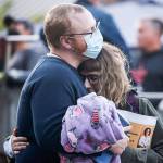 Austin Nix and Madison Nix take comfort Tuesday afternoon at the Snohomish County Campus Plaza in Everett. (Kevin Clark / The Herald)