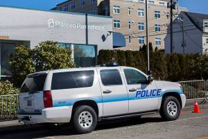 Everett Police escort a pro-life supporter down the center of 32nd Street due to barriers set up along the sidewalk around Planned Parenthood as a part of a "time, place and manner restriction" imposed by the city on Wednesday, April 14, 2021 in Everett, Wa. (Olivia Vanni / The Herald)