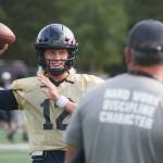 Arlington senior quarterback Trent Nobach talks with head coach Greg Dailer during practice on Tuesday, Aug. 31, 2021 in Arlington, Washington. Nobach, one of the top quarterbacks in the state, is back from injury after suffering a broken collarbone in the first game of this past spring's season. (Andy Bronson / The Herald)