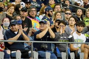Fans, most without masks, in the stands at Lumen Field watch an NFL football preseason game between the Seattle Seahawks and the Los Angeles Chargers, Saturday, Aug. 28, 2021, in Seattle. (AP Photo/Elaine Thompson)