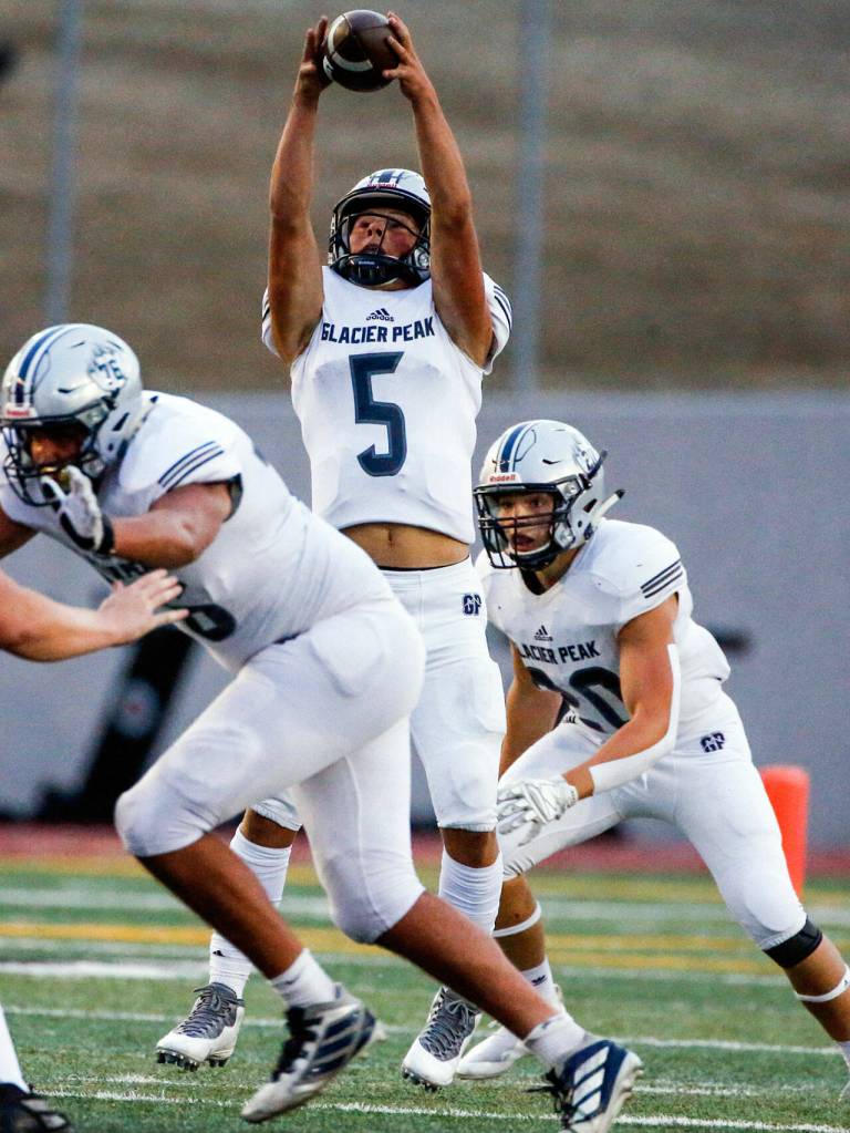 Glacier Peaks River Lien reaches for a high snap Friday night at Veterans Memorial Stadium in Snohomish September 3, 2021. (Kevin Clark / The Herald)