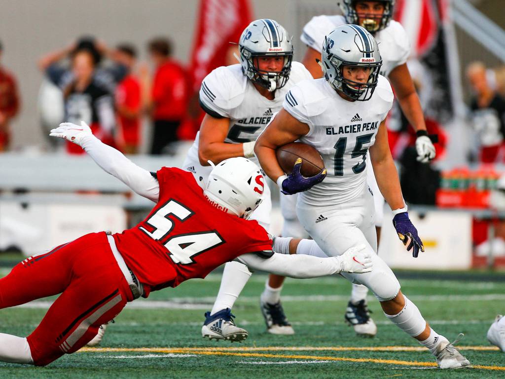Glacier Peaks Trey Leckner rushes with Snohomishs Brayden Ulrich attempting a tackle Friday night at Veterans Memorial Stadium in Snohomish September 3, 2021. (Kevin Clark / The Herald)
