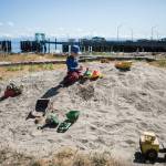 John Roache, 5, plays in the sand with toy trucks at Clinton Beach Park, a good place for kids to blow off steam while waiting for a ferry. (Olivia Vanni / The Herald)