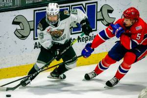 Silvertips' Matthew Ng (left) and Chiefs' Jordan Chudley vie for control the puck during the final home game Friday night at Angel of the Winds Arena in Everett on May 7, 2021.  (Kevin Clark / The Herald)