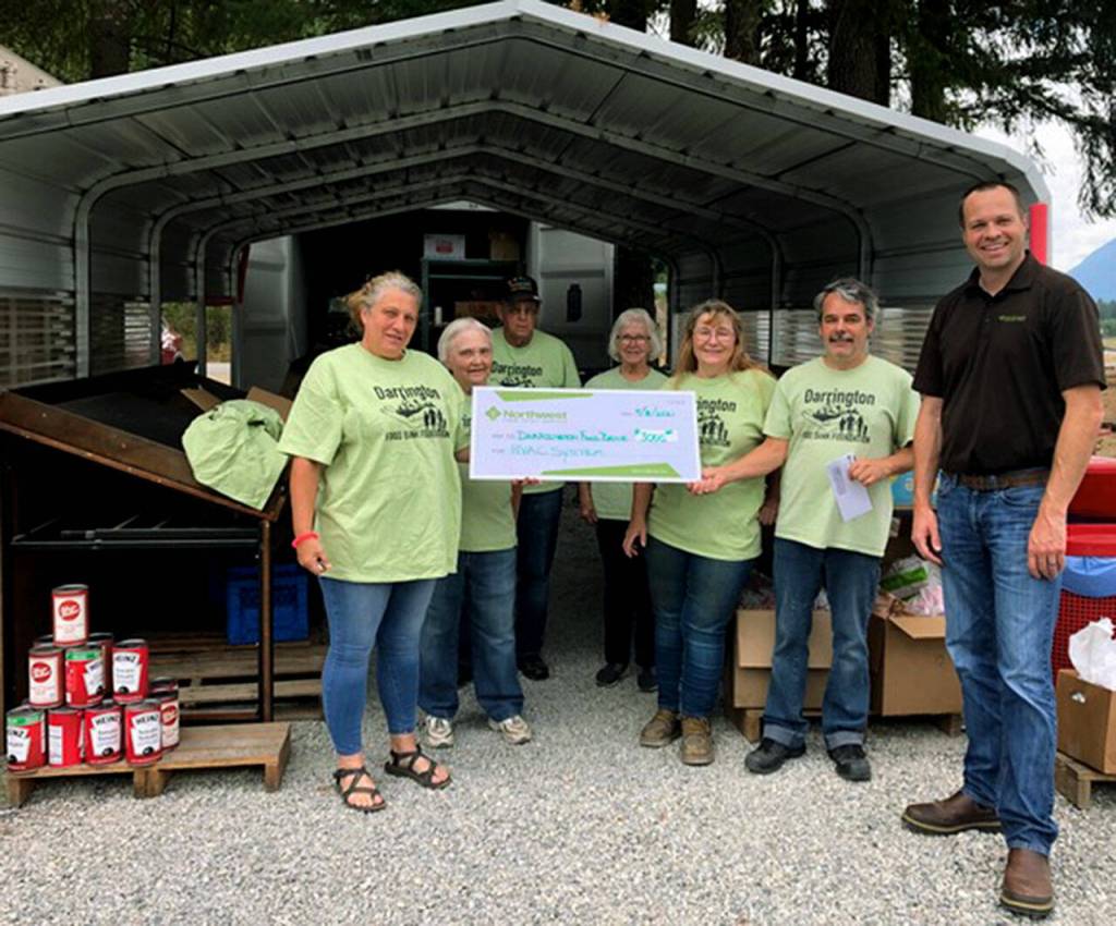 Trevor Faucett of the Northwest Farm Credit Bureau recently presented volunteers with the Darrington Food Bank a $3,000 check to help buy an HVAC system to keep food safe before distribution. (NW Farm Credit Bureau)