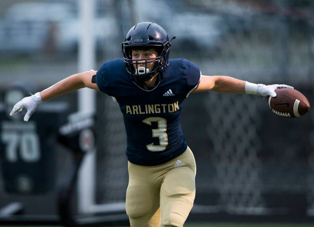Arlingtons Gage Price celebrates after scoring a touchdown during the game against Oak Harbor on Friday, Sept. 10, 2021 in Arlington, Wa. (Olivia Vanni / The Herald)