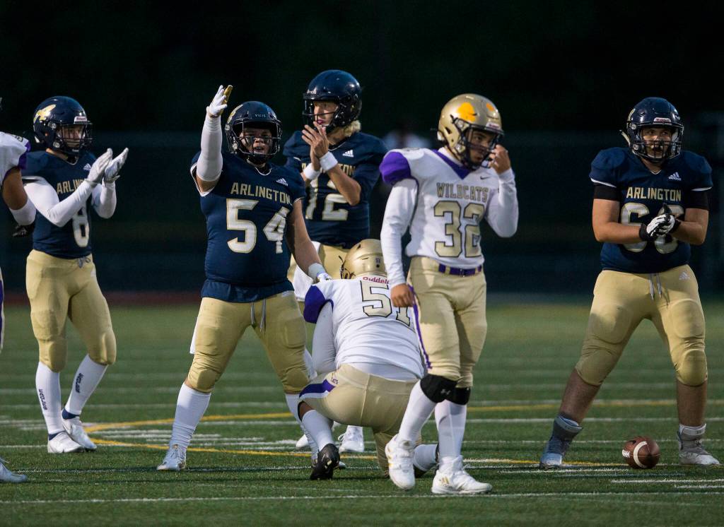 Arlington players react to a false start by Oak Harbor during the game on Friday, Sept. 10, 2021 in Arlington, Wa. (Olivia Vanni / The Herald)