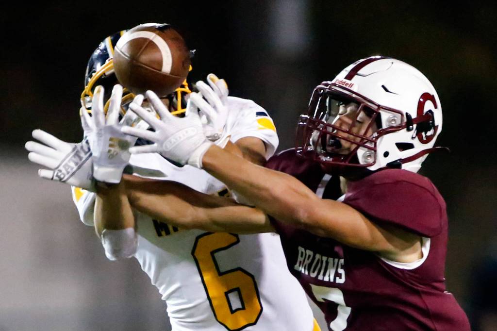 Mariners Isaiah Cuellar, left, and Cascades Zach Lopez reach for a pass intended for Lopez Friday evening at Everett Memorial Stadium on September 10, 2021. (Kevin Clark / The Herald)