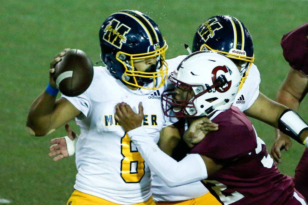 Mariners Damien Bagley avoids the sack attempt by Cascades Juan Ramirez Friday evening at Everett Memorial Stadium on September 10, 2021. (Kevin Clark / The Herald)