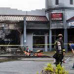 Owners of Taste Rice Noodle talk to a South County firefighter as they survey the damage of a fire at Plum Tree Plaza off of Highway 99 on Saturday, Sept. 11, 2021 in Edmonds, Wa. (Olivia Vanni / The Herald)
