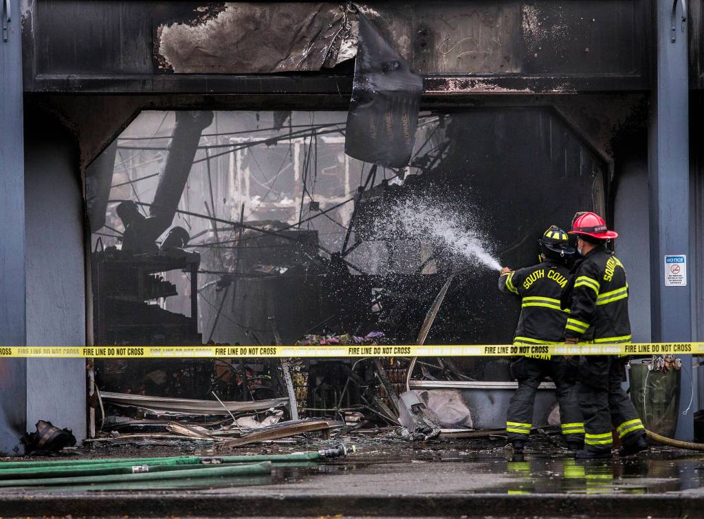 South County firefighters spray water into a business with fire damage at Plum Tree Plaza off of Highway 99 on Saturday, Sept. 11, 2021 in Edmonds, Wa. (Olivia Vanni / The Herald)