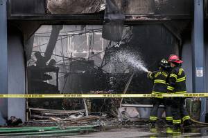 South County firefighters spray water into a business with fire damage at Plum Tree Plaza off of Highway 99 on Saturday, Sept. 11, 2021 in Edmonds, Wa. (Olivia Vanni / The Herald)