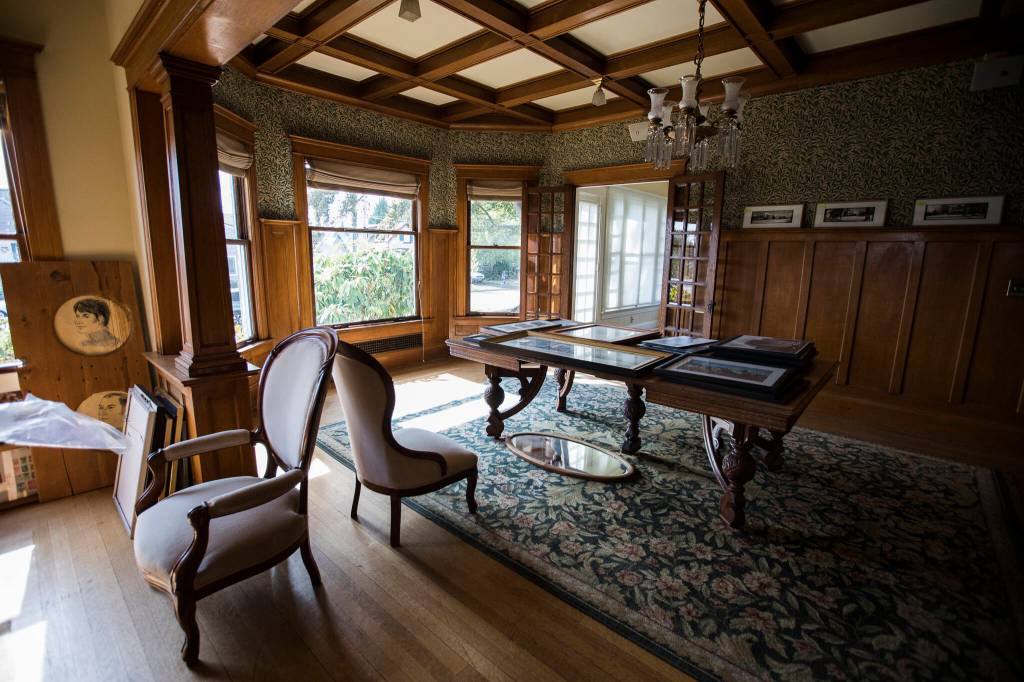 Historic images sit on an original table inside the dining area of the Van Valey House on Wednesday in Everett. (Olivia Vanni / The Herald)
