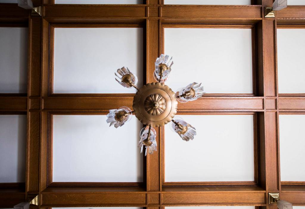 A light fixture hangs from the coffered ceiling in the dinning area of the Van Valey House on Wednesday in Everett. (Olivia Vanni / The Herald)