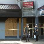 Mark Choi (right) and an employee leave his office in the Plum Tree Plaza after firefighters checked for hot spots on Monday in Edmonds. (Andy Bronson / The Herald)