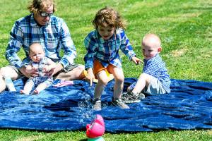 Erik Denton (left) holds his youngest daughter, Sierra, while his daughter Joanna chases bubbles and son Terry watches. Denton's three kids were killed in April. (Contributed)