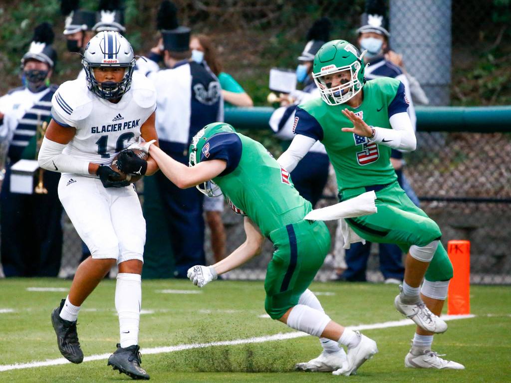 Glacier Peaks Torey Watkins makes a reception for a short run for a touchdown with Woodinvilles Cash Sanders, center, and Woodinvilles Tyler Jones defendingThursday evening at Pop Keeney Stadium in Bothell on September 16, 2021. (Kevin Clark / The Herald)