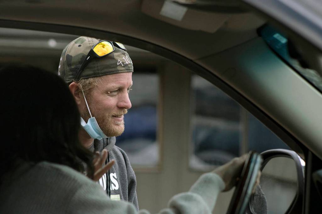 Erik Denton talks to a member of the community during the familys toy drive. Dentons three kids were killed in April. (Isabella Breda / The Herald)