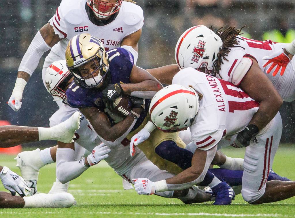 Washington Huskies outside linebacker Taj Davis is tackled by multiple Arkansas State players during the game against Arkansas State on Saturday, Sept. 18, 2021 in Seattle, Wa. (Olivia Vanni / The Herald)