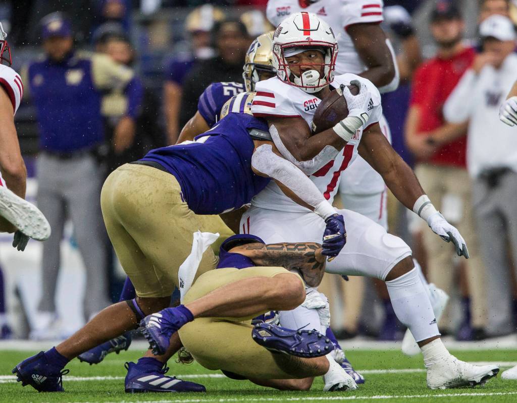Arkansas States Alan Lamar is tackled by Washington Huskies defensive back Asa Turner and defensive lineman Tuli Letuligasenoa during the game against Arkansas State on Saturday, Sept. 18, 2021 in Seattle, Wa. (Olivia Vanni / The Herald)