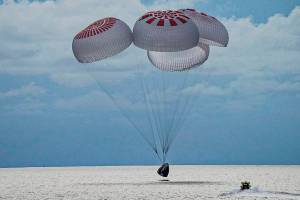 In this image taken provided by SpaceX, a capsule carrying four people parachutes into the Atlantic Ocean off the Florida coast, Saturday, Sept. 18, 2021. The all-amateur crew was the first to circle the world without a professional astronaut.  (SpaceX via AP)