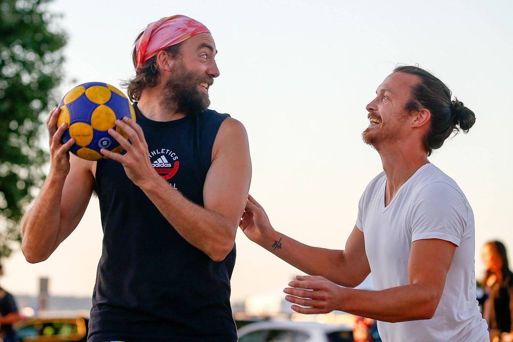 Bill Johnson, left, looks to pass with Sean Hermis defending while playing korfball Sept. 9 at Mukilteo Beach. (Kevin Clark / The Herald)
