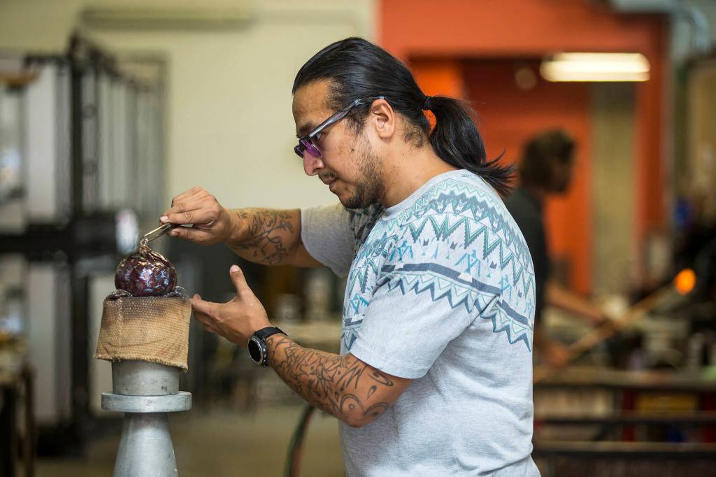 Artist Emmanual Aguilera, working in the Schacks hot shop, puts a stem on a glass pumpkin for Schack-toberfest, which opens Sept. 23. (Andy Bronson / The Herald)
