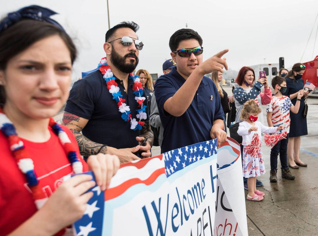 Family members and friends look for loved ones as the USS Kidd docks on Friday in Everett. (Olivia Vanni / The Herald)