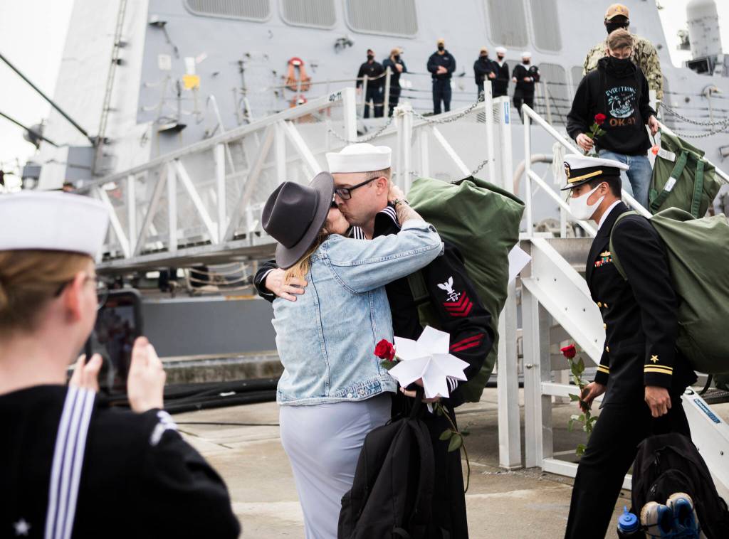 Danica Mooneyham shares a kiss with her husband, Logan Mooneyham, after his return from deployment on the USS Kidd on Friday in Everett. (Olivia Vanni / The Herald)