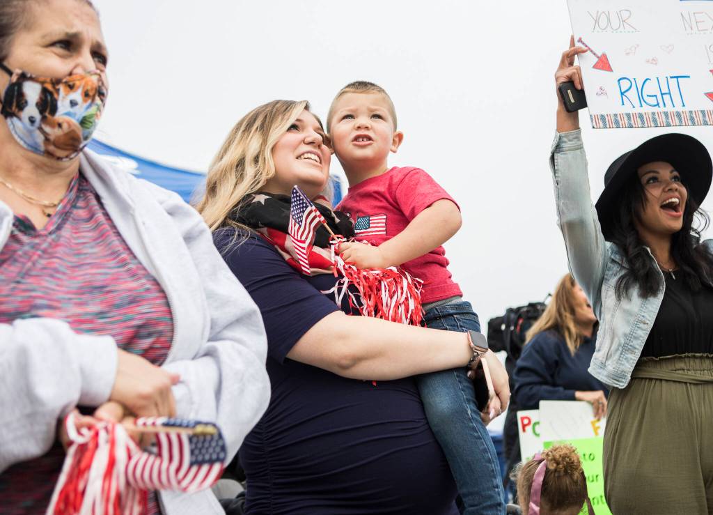 Family members and friends look for loved ones as the USS Kidd docks after returning from deployment on Friday in Everett. (Olivia Vanni / The Herald)