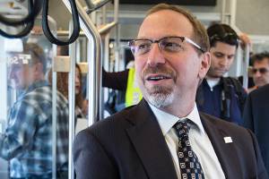 Sound Transit CEO Peter Rogoff (center) takes a ride on light rail from the Angle Lake Station in Seatac with King County Executive Dow Constantine (left) on Sept. 21, 2016. (Ian Terry / Herald file)