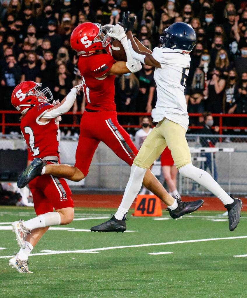 Stanwoods Isaiah Hughes intercepts a pass intended for Arlingtons Elijah Jackson during the Stilly Cup on Friday night at Stanwood High School. (Kevin Clark / The Herald)