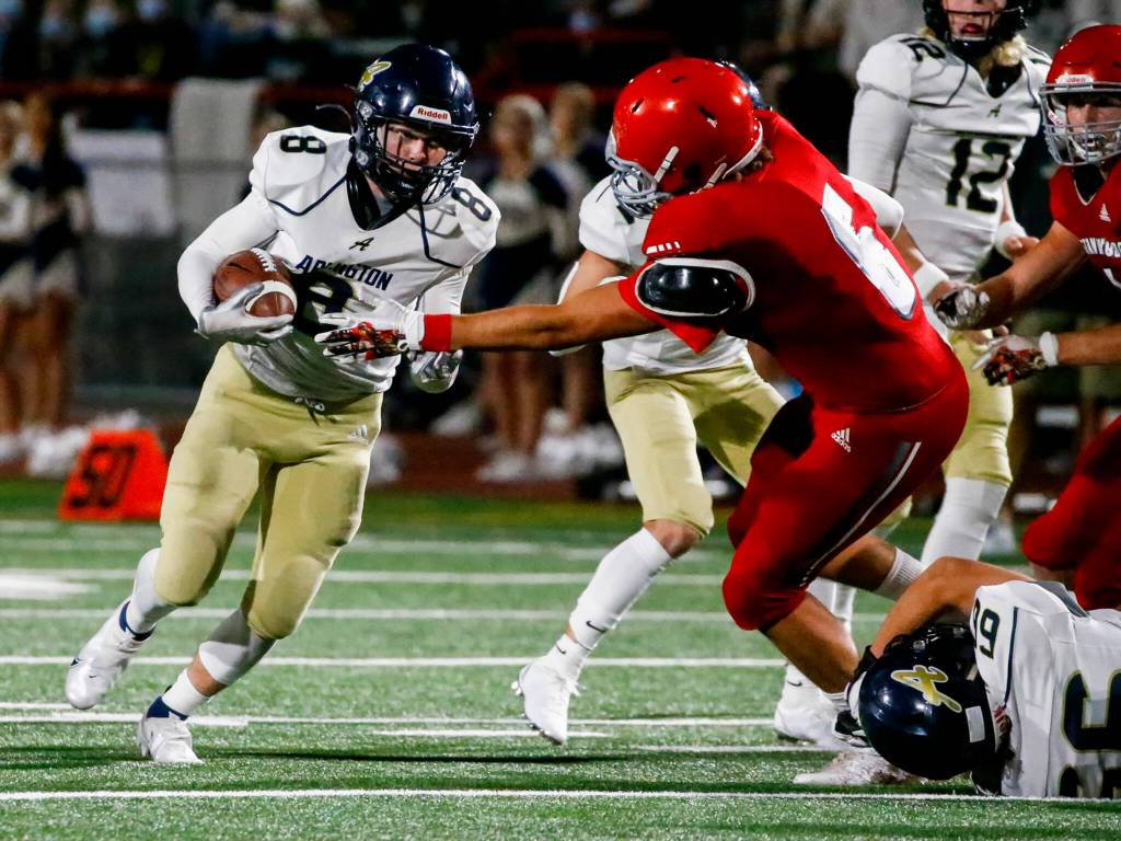 Arlingtons RJ Gese rushes with Stanwoods Michael Mascotti closing during the Stilly Cup on Friday night at Stanwood High School. (Kevin Clark / The Herald)
