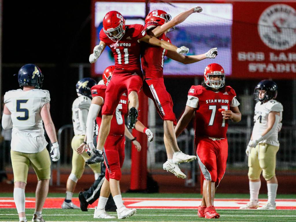 Stanwoods Isaiah Hughes (left) and JT McLaughlin celebrate a defensive stop against Arlington during the Stilly Cup on Friday night at Stanwood High School. (Kevin Clark / The Herald)