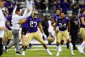 Washington players and coaches celebrate beating California in an NCAA college football game Saturday, Sept. 25, 2021, in Seattle. Washington won 31-24 in overtime. (AP Photo/Elaine Thompson)