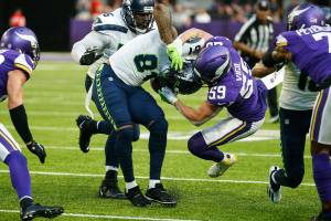 Minnesota Vikings outside linebacker Nick Vigil (59) tackles Seattle Seahawks tight end Gerald Everett (81) in the first half of an NFL football game in Minneapolis, Sunday, Sept. 26, 2021. (AP Photo/Bruce Kluckhohn)