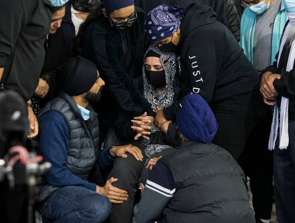 Jaswant Singh, whose husband TejPal Singh was shot and killed while he worked Sunday, is consoled by family and friends during his candlelight vigil Wednesday in Lynnwood. (Olivia Vanni / The Herald)