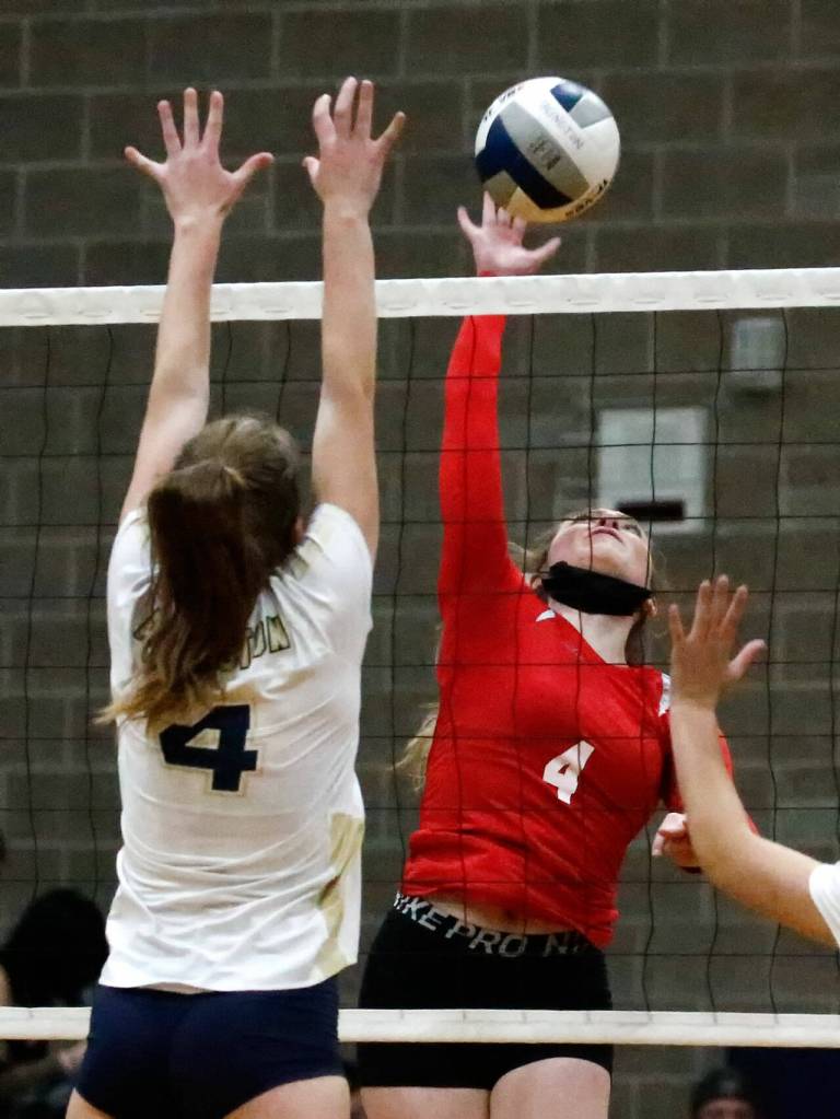 Arlingtons Malia Shepherd jumps to block Snohomishs Mikala Milburn Wednesday night at Arlington High School on September 29, 2021. The Eagles won in straight sets. (Kevin Clark / The Herald)