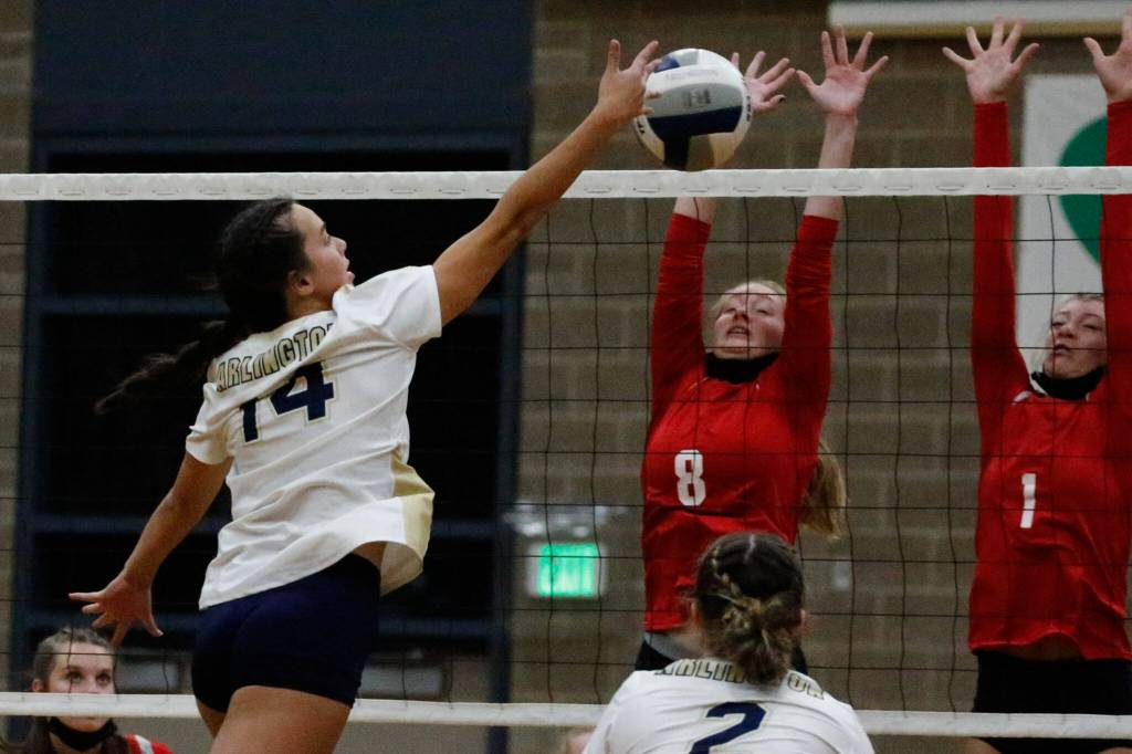 Arlingtons Chloe Fochesato attempts a kill with Snohomishs Reagan Bullock and Snohomishs Kelsey Nichols defending Wednesday night at Arlington High School on September 29, 2021. The Eagles won in straight sets. (Kevin Clark / The Herald)
