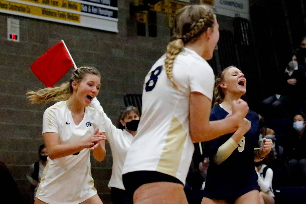 Arlington celebrates a point against Snohomish Wednesday night at Arlington High School on September 29, 2021. The Eagles won in straight sets. (Kevin Clark / The Herald)