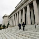 FILE - In this May 17, 2018, file photo attorneys walk up the steps of the Washington Supreme Court building, the Temple of Justice, in Olympia, Wash. The court on Thursday, Sept. 30, 2021, unanimously upheld the Washington's tax on big banks aimed at providing essential services and improving the state's regressive tax system. The 1.2% business and occupation surtax, a tax added on top of other taxes — was passed by the Legislature in 2019. (AP Photo/Ted S. Warren, File)