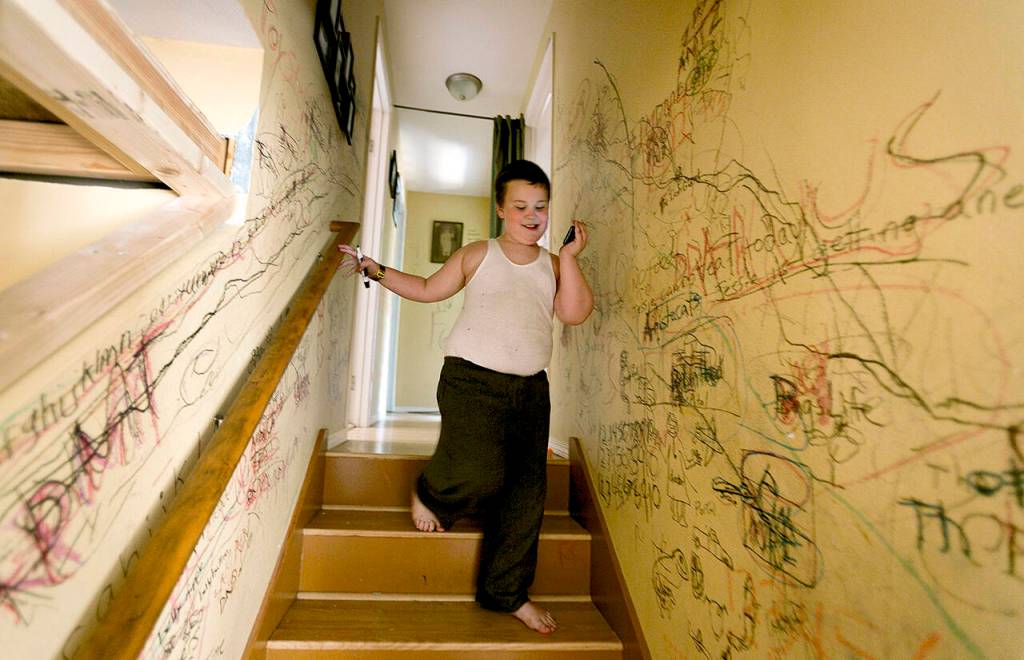 Jessie Pyles run excitedly through his home in Lake Stevens, carrying his ever-present black marker and listening to music. I know what most people would say, Oh my God, you let your kid write on the wall, Cheryl Pyles said. But, to me, its like, Look! My kid can write! (Kevin Clark / Herald file)
